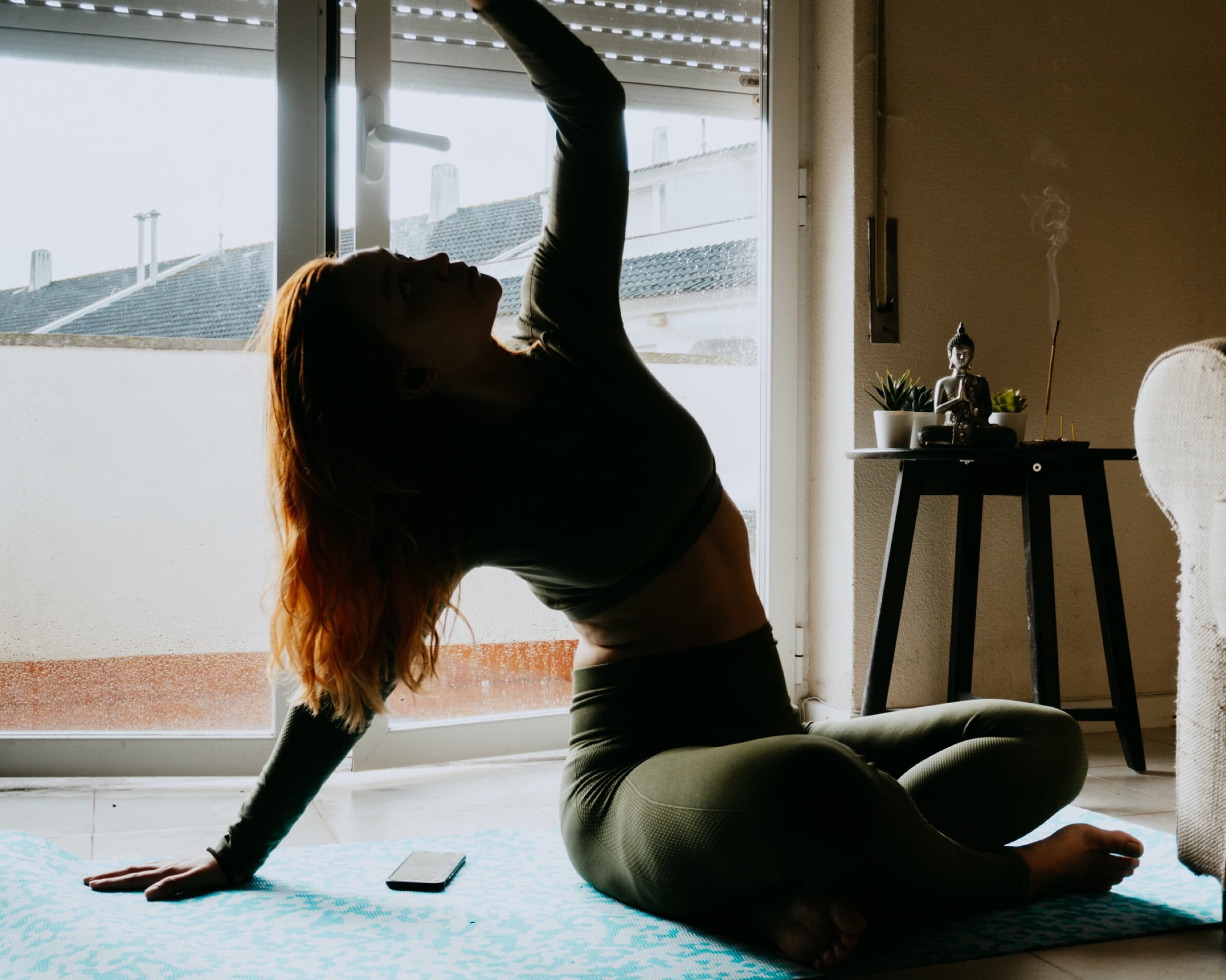 A woman doing yoga in front of her Leesa mattress