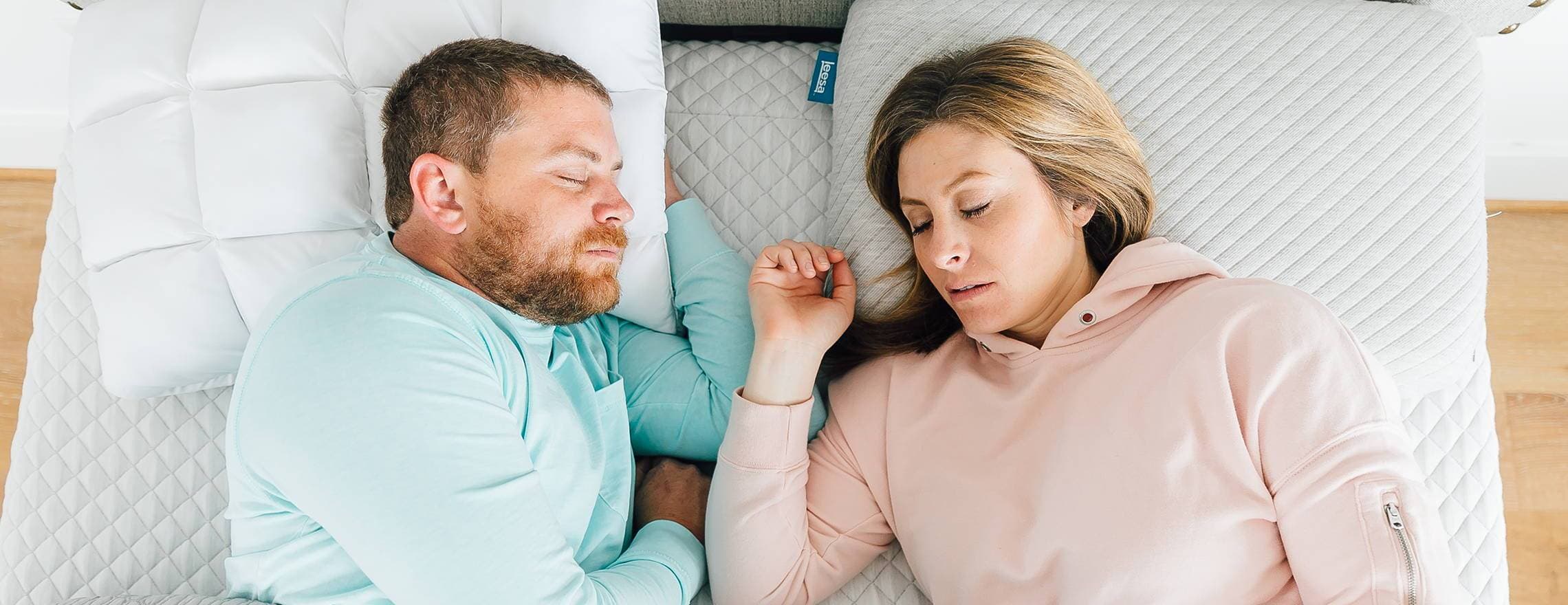 A couple sleeping on a Leesa mattress and pillows