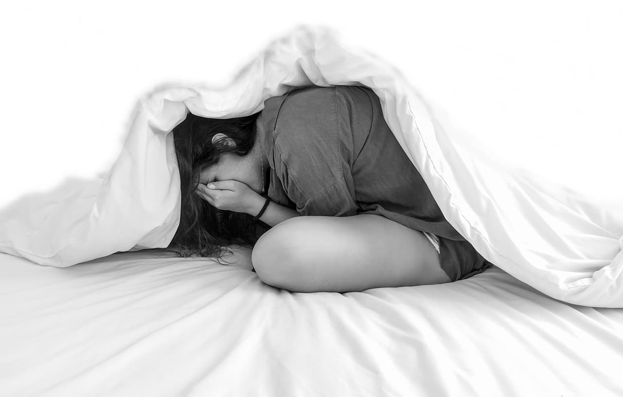 A woman suffering from sleeping anxiety under a Leesa duvet