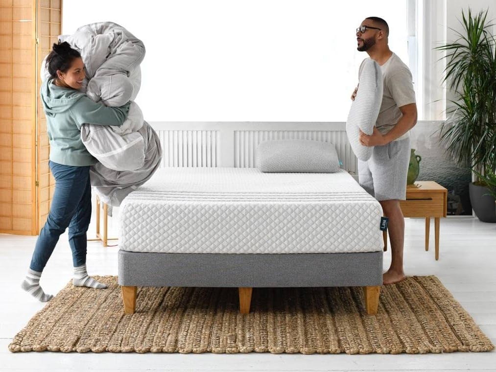 A couple making up a Leesa mattress