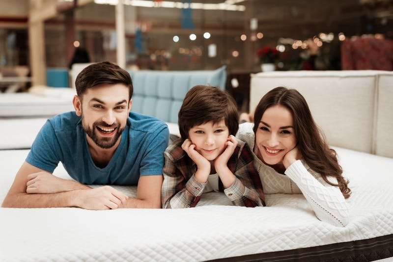 A couple with their child on a memory foam mattress
