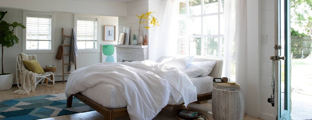 leesa_mattress_with_a_white_comforter_in_a_decorated_room_and_an_outdoor_view
