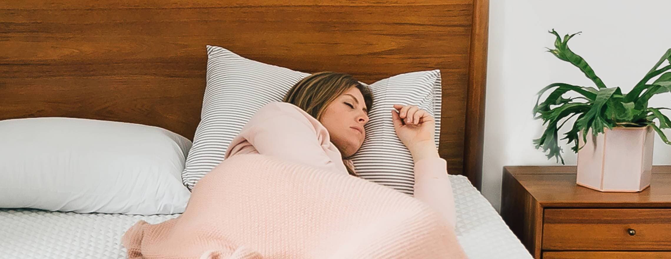Lady resting on a Leesa matttress and pillow
