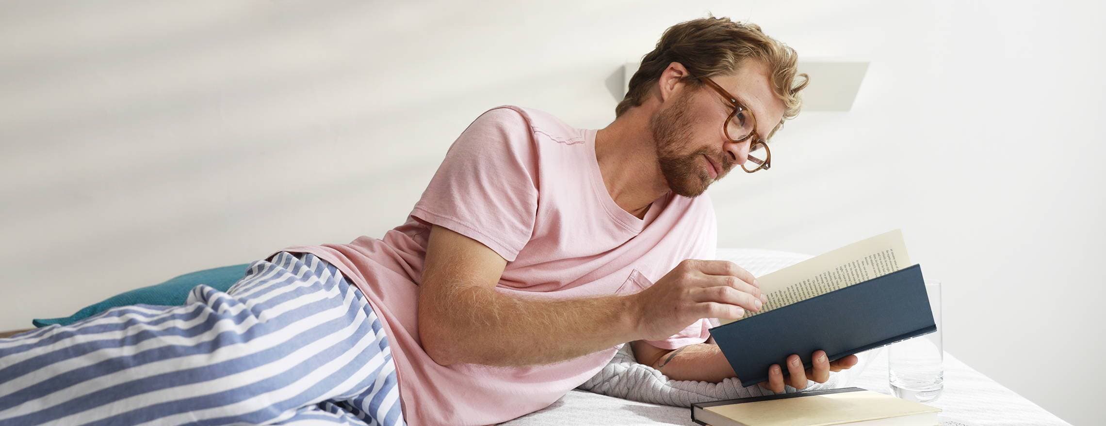 A man reading a book on a Leesa mattress.