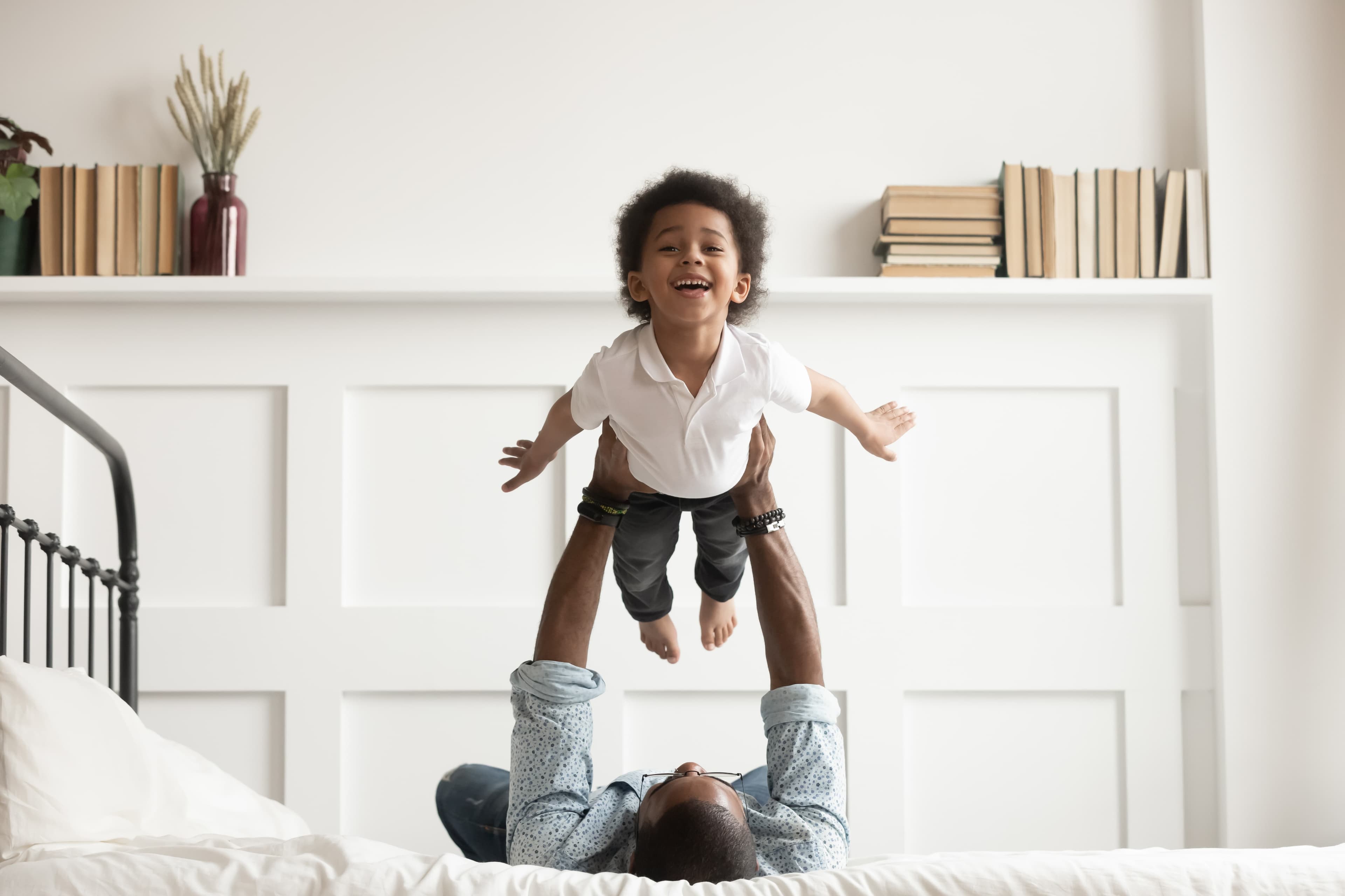 A father and his son playing in the bedroom