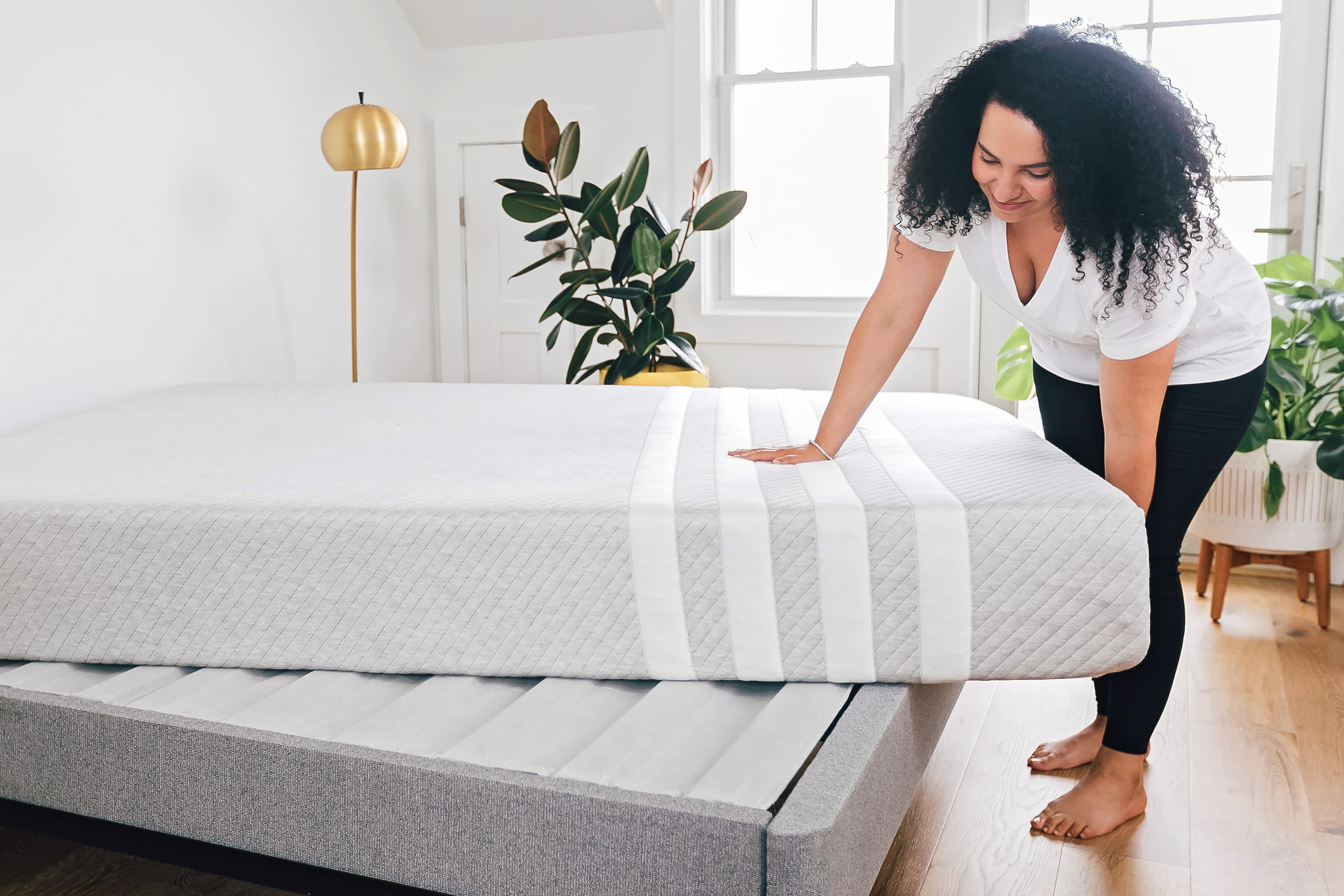 A woman setting up her Leesa Original Hybrid mattress