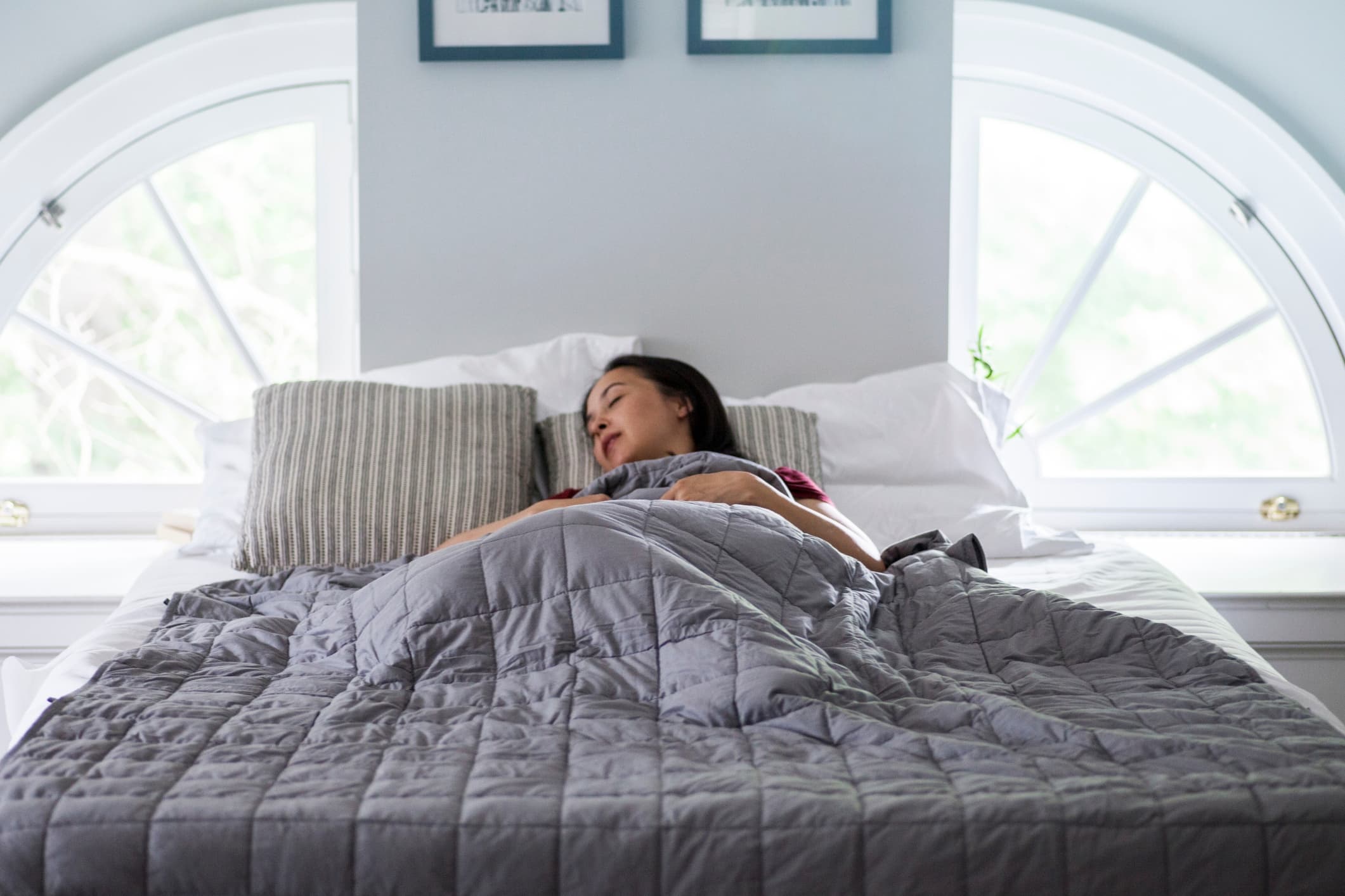 woman sleeping under a weighted blanket