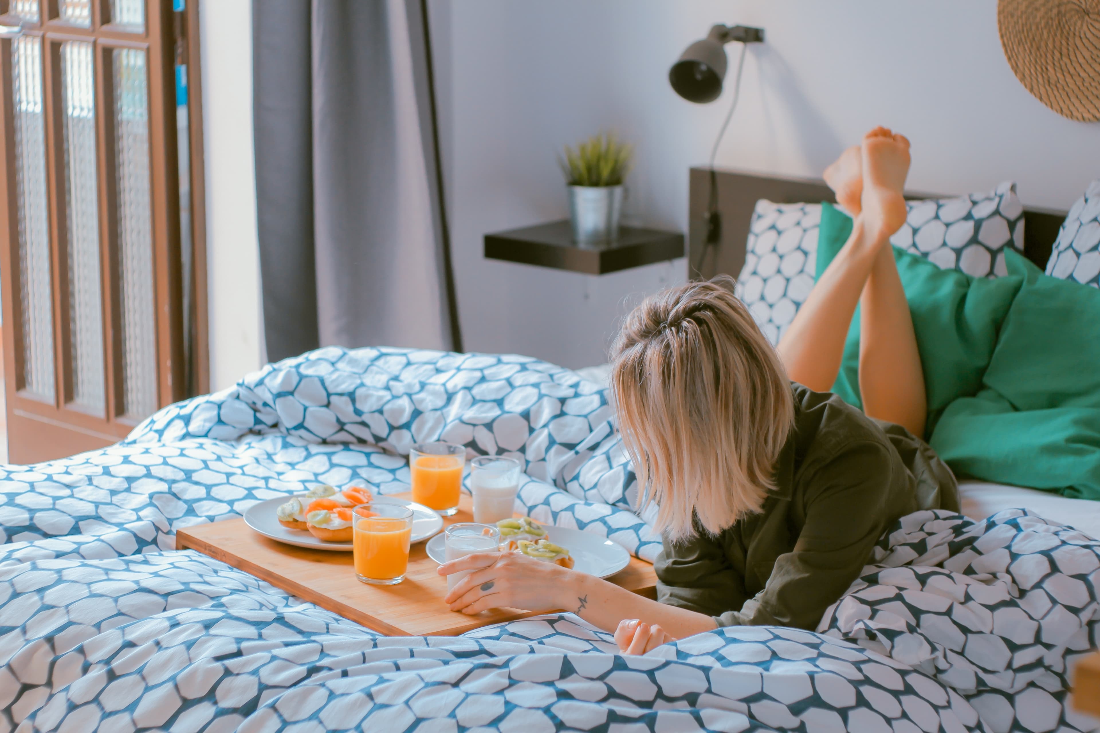 A woman having breakfast on a Leesa duvet cover