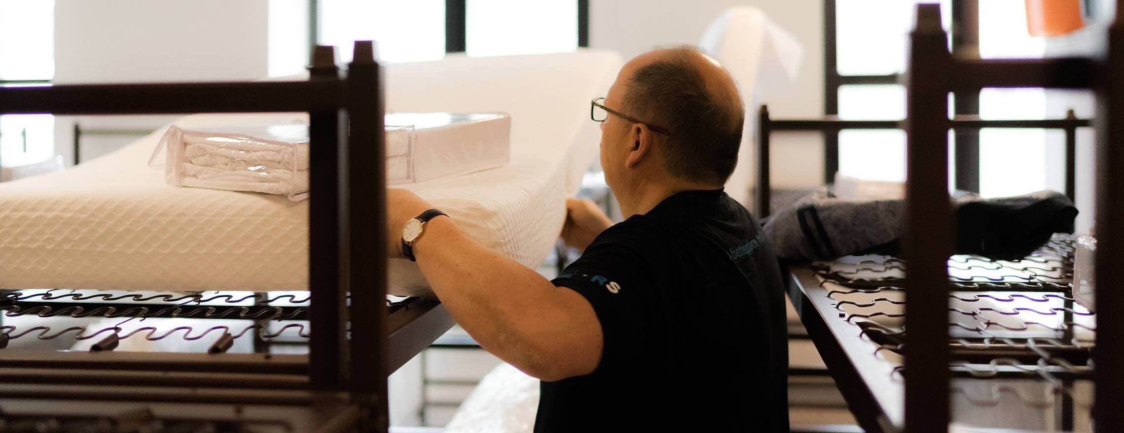 A man fitting a Leesa twin on a bunk bed